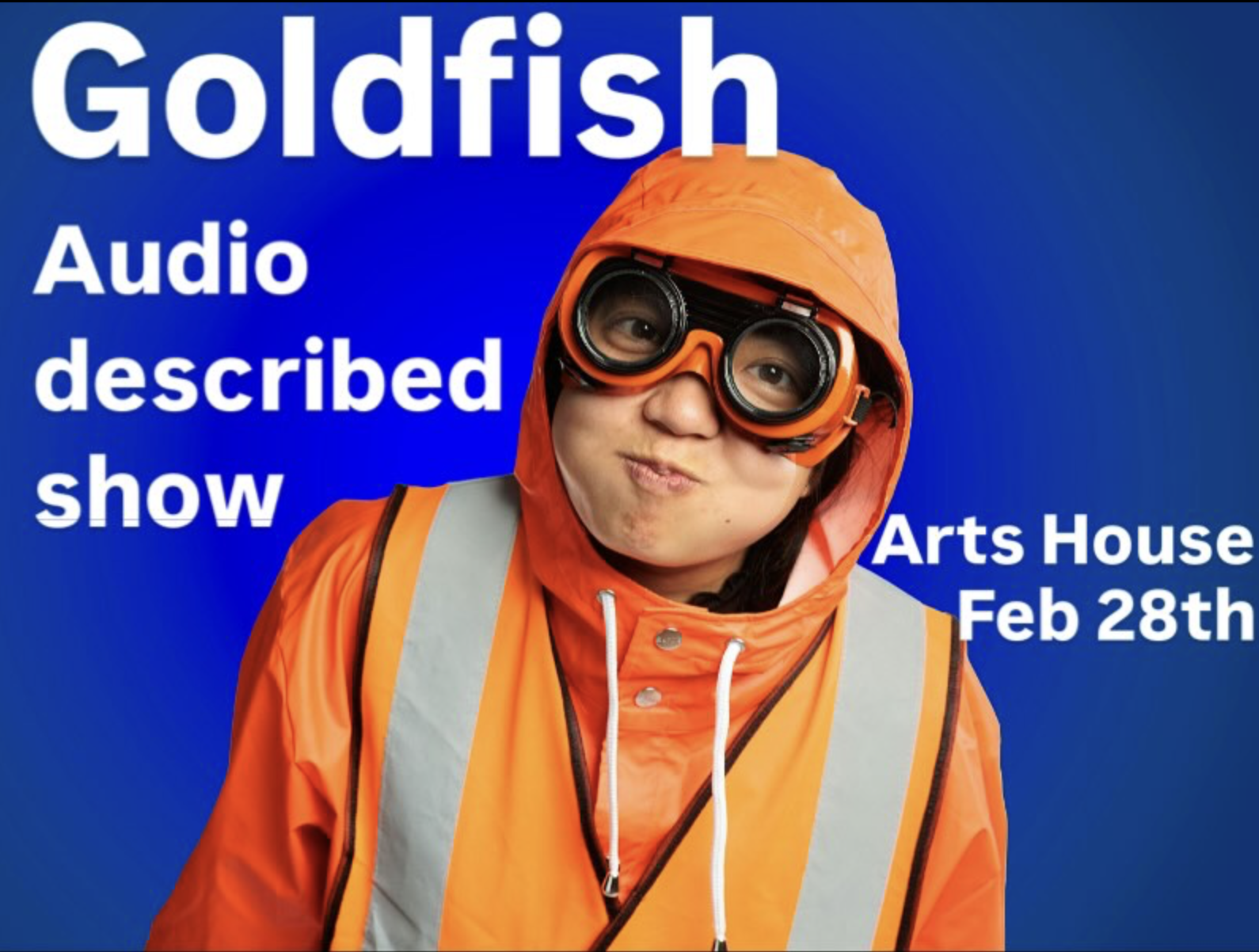 A head and shoulders photo of a person wearing a bright orange raincoat with a hood against a blue background. They are wearing large, round, black rimmed goggles and are making a playful, exaggerated facial expression, puffing out their cheeks, looking directly at us. White text to either side of them reads: Goldfish, Audio described show, Arts House, Feb 28th.